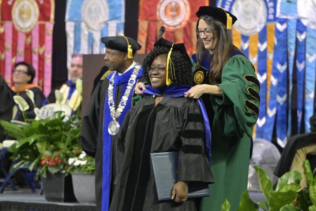 Dr. Rosina Counter being hooded by Dr. Sarah Bleiler-Baxter.